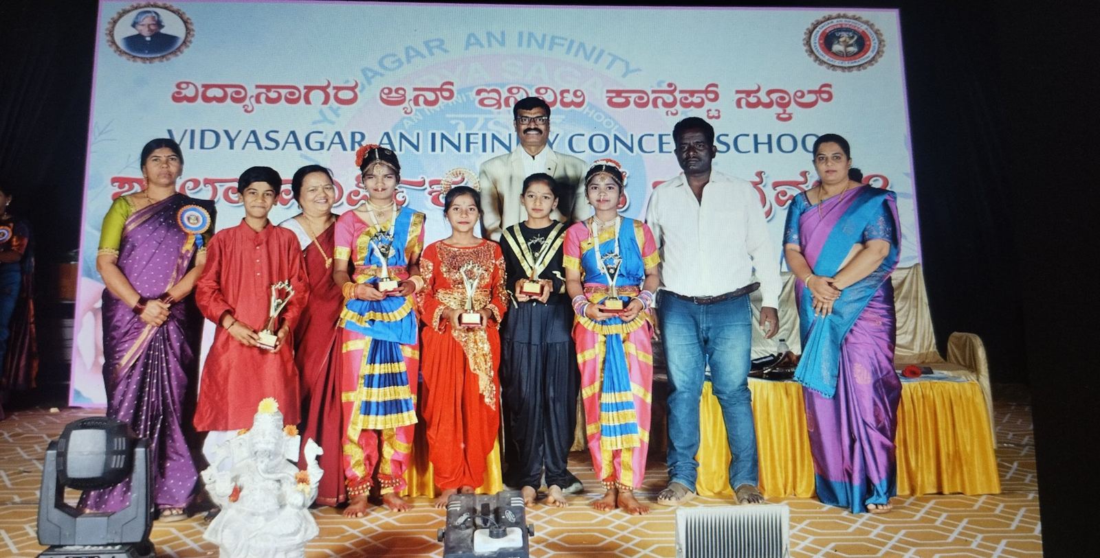 Prize winners in costume on stage at Annual Day